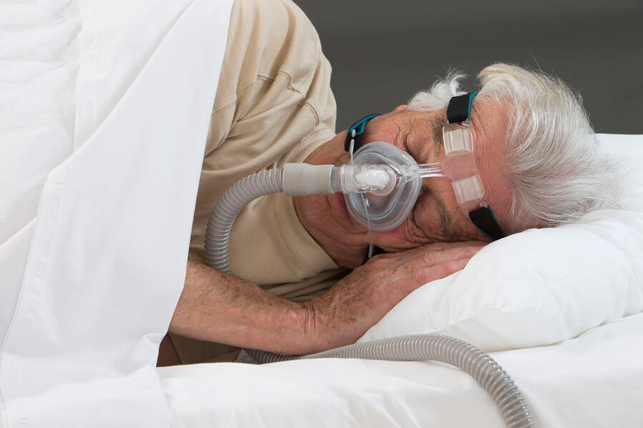 Older man asleep wearing cpap mask