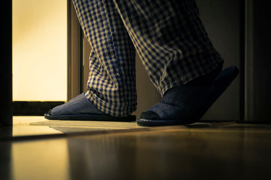 Man wearing slippers exiting room