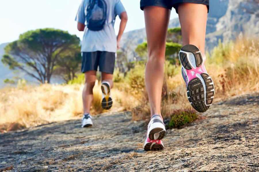 Man and woman running on trail