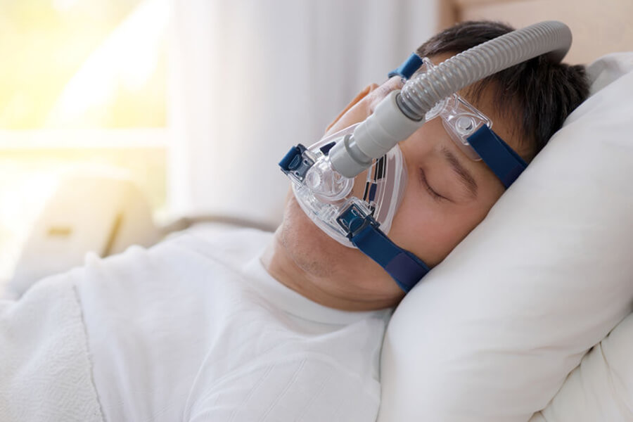 Man asleep wearing CPAP machine