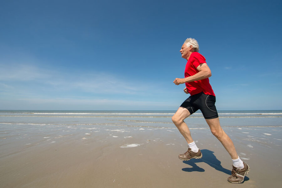 Older man running on the beach