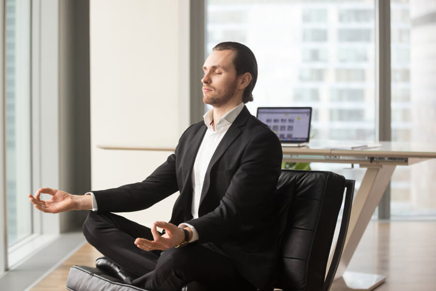 Male meditating in office