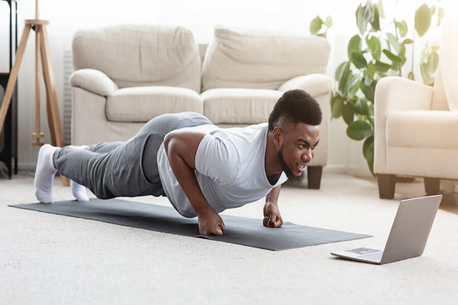 Male performing plank inside home