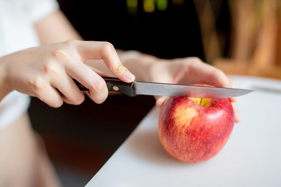 Female slicing apple with knife