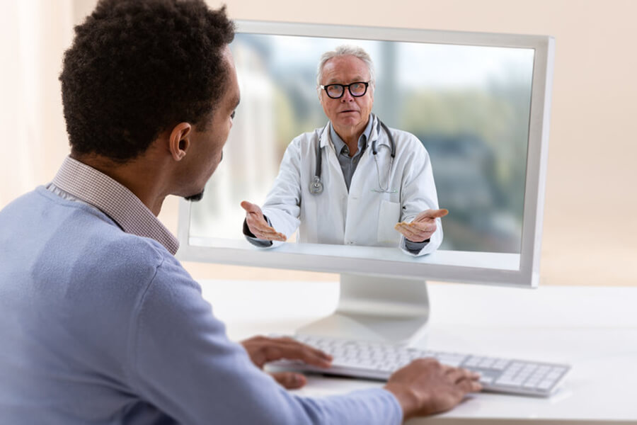 Male speaking to doctor on computer