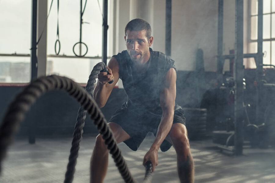 Male athlete performing rope exercise