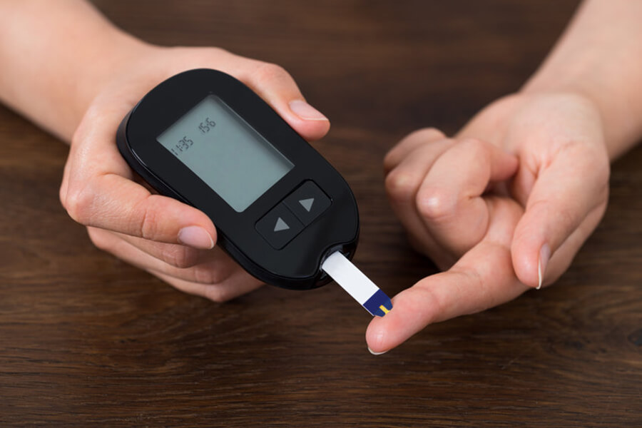 Woman holding glucometer