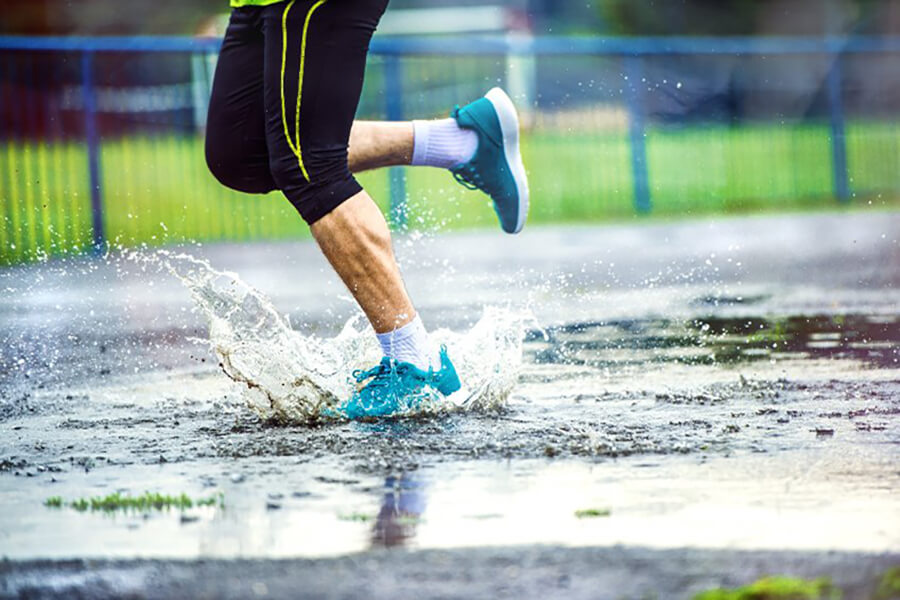 Male athlete running in rain