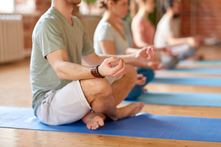 Male athlete meditating with group
