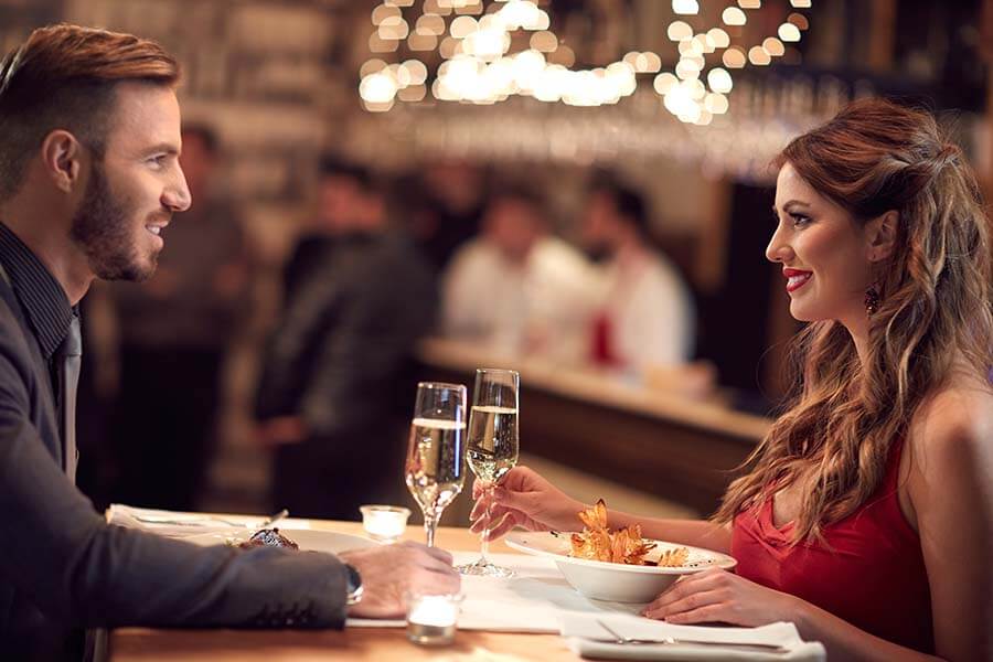 Female and male enjoy at restaurant with dinner together